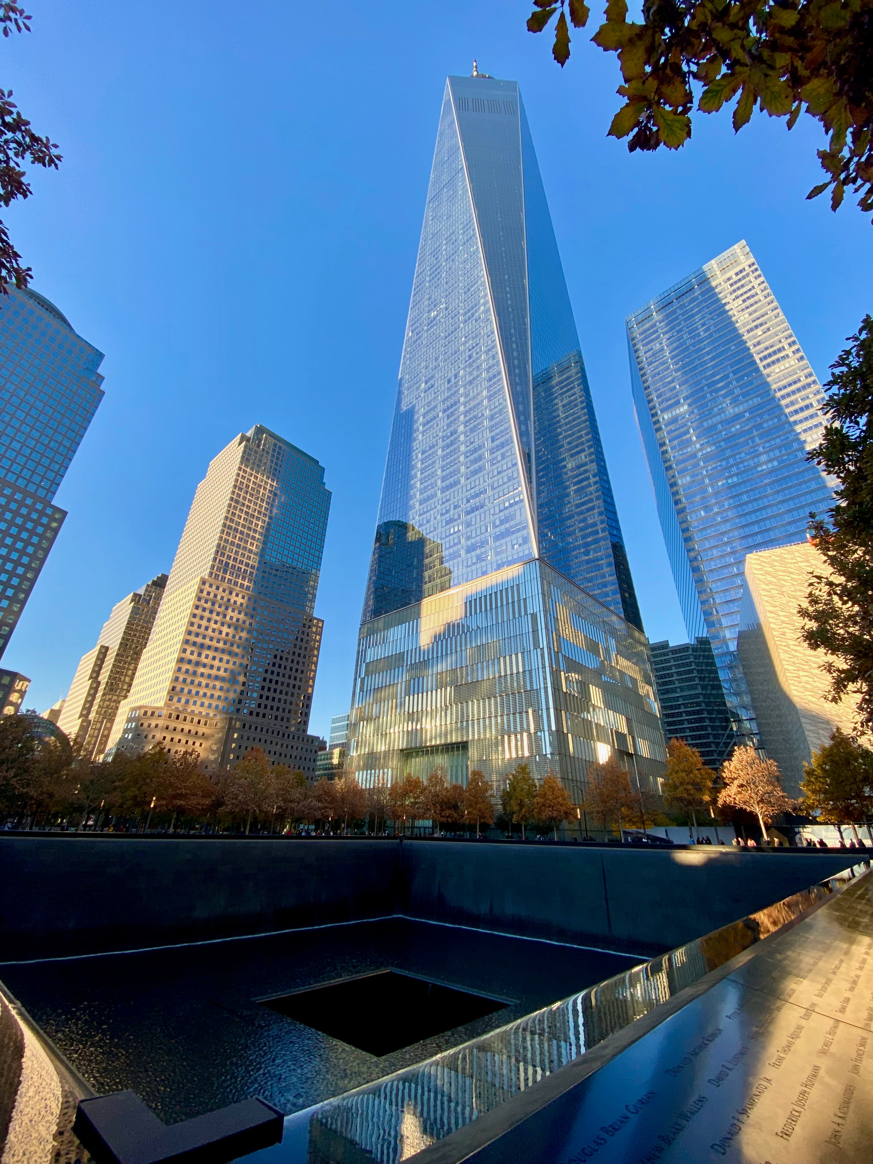 A memorial pool with One World Trade Center rising behind it.