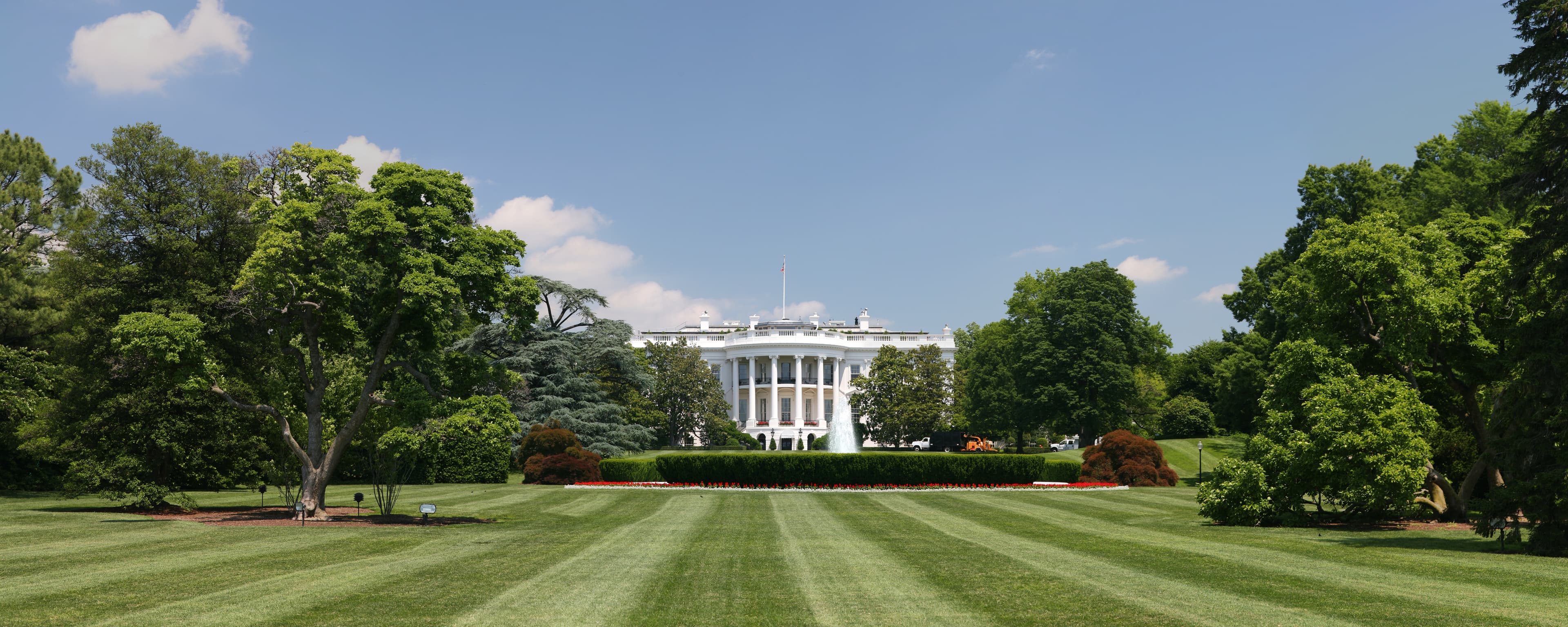 Hero photo: Daniel Schwen, CC BY-SA 3.0, via Wikimedia Commons. Caption: The South Front across the South Lawn — the view from the Ellipse, the public's postcard of the White House, with the Truman Balcony above the South Portico.