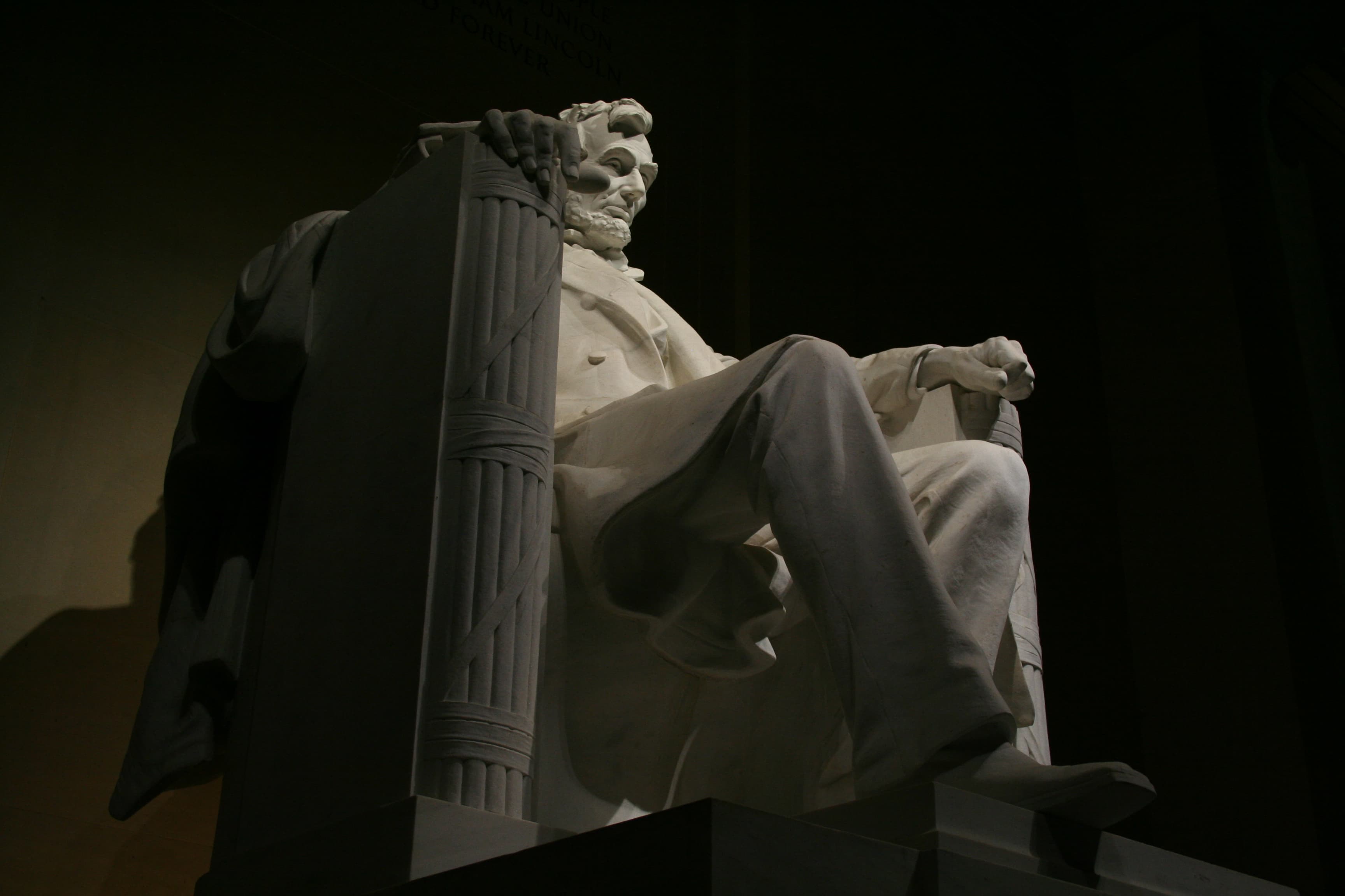 The seated Lincoln statue at night, lit inside the memorial chamber
