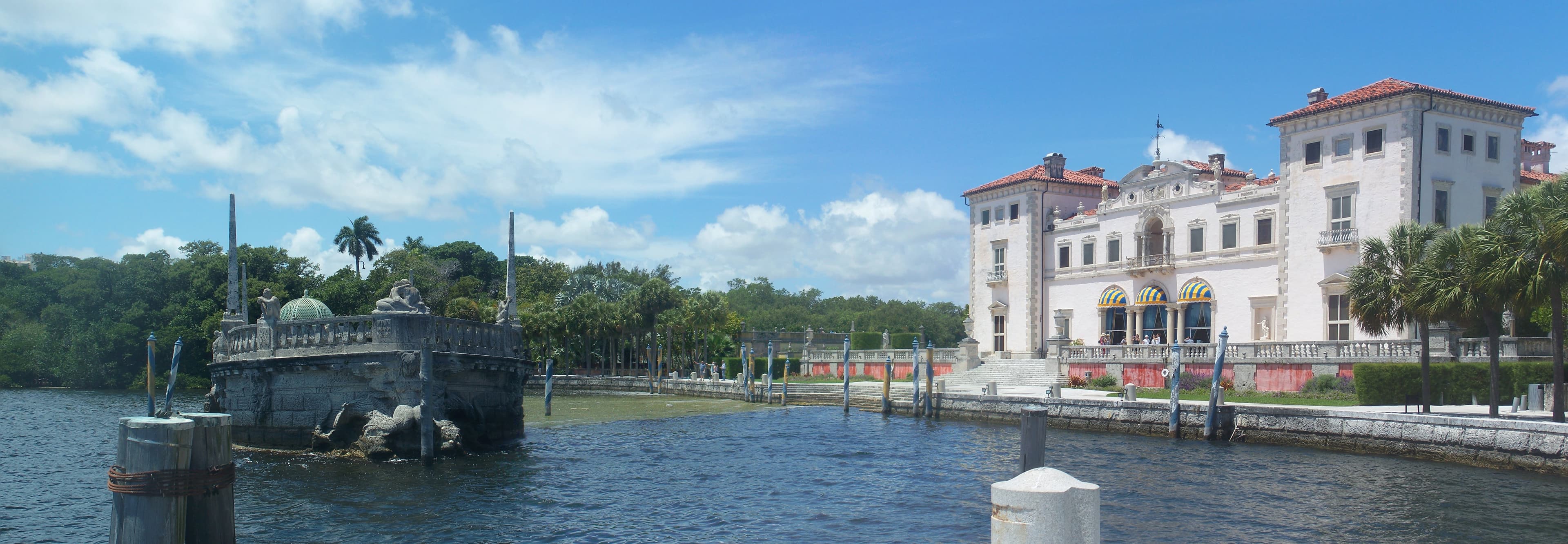 Vizcaya's Main House and the stone Barge in Biscayne Bay — James Deering's bay-front estate, with Calder's carved breakwater riding at anchor in front of the east terrace.