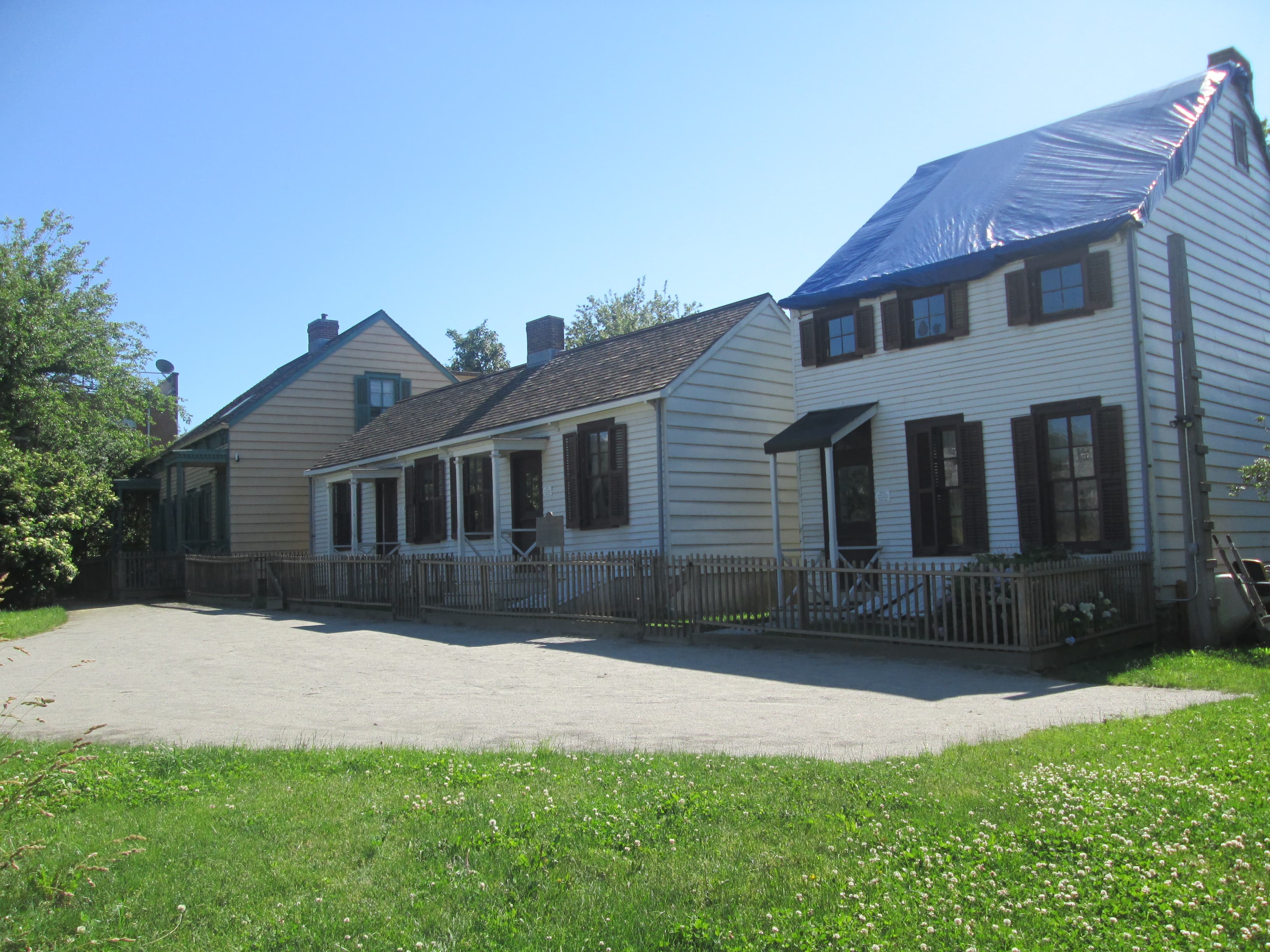 The historic Hunterfly Road wood-frame houses — white clapboard 19th-century homes with dark shutters and picket fencing